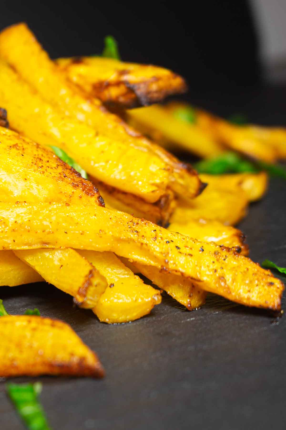 Crispy oven-baked rutabaga fries on the black board.