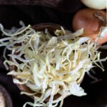 A bowl of onion flakes on a table.