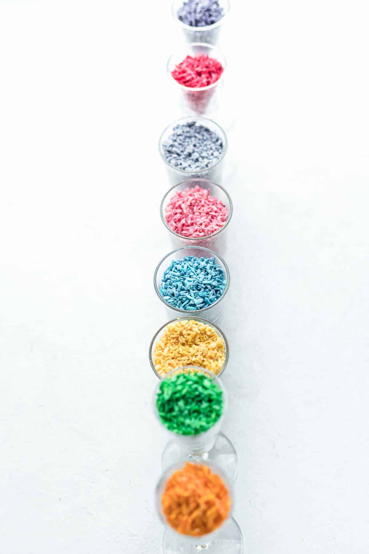 Colorful sprinkles in a row on a white surface.