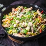 A skillet filled with vegetables and chicken.