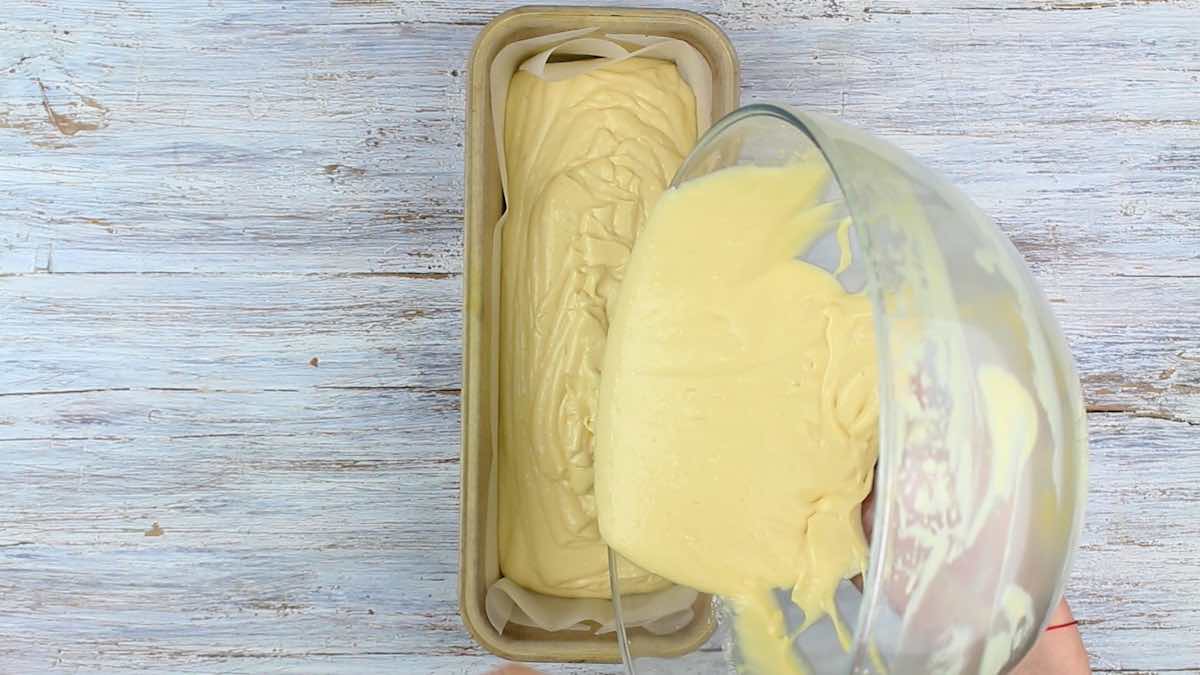 Pouring bread batter into a pan.