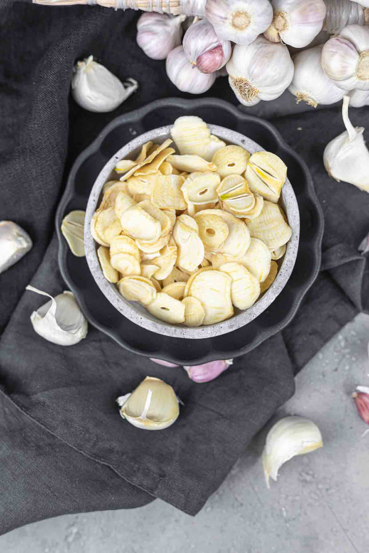 Garlic chips in a bowl on a grey background.