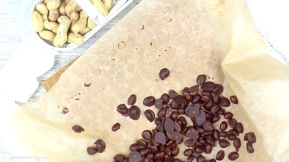 A scattering of chocolate peanuts on parchment paper.