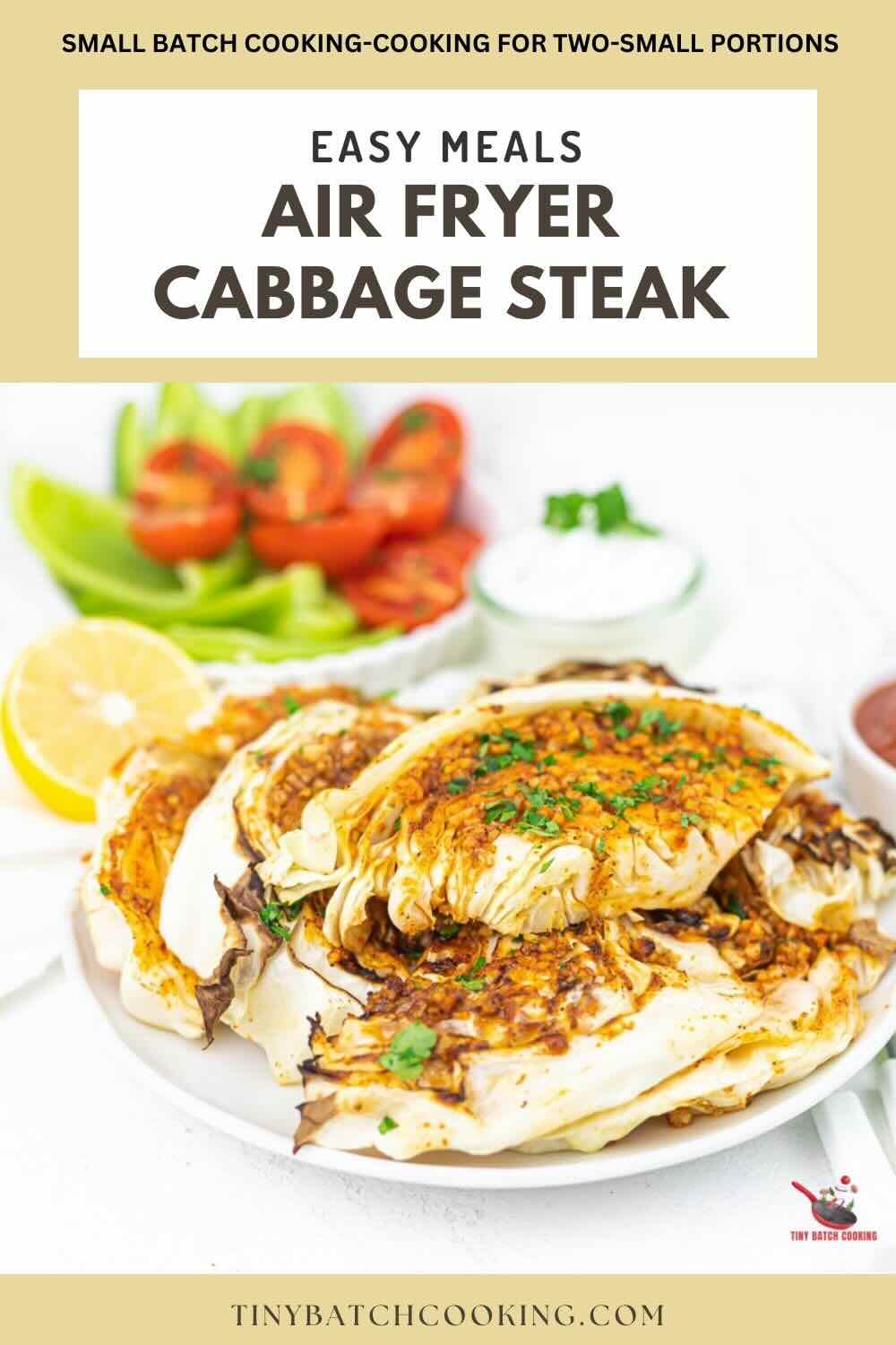 A plate of air fryer cabbage steak is garnished with herbs and served alongside fresh vegetables. Text reads "Easy Meals: Air Fryer Cabbage Steak" and "TinyBatchCooking.com".