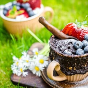 A chocolate cake in a cup topped with berries.