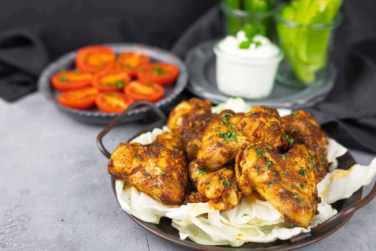 A plate of seasoned and cooked chicken wings.