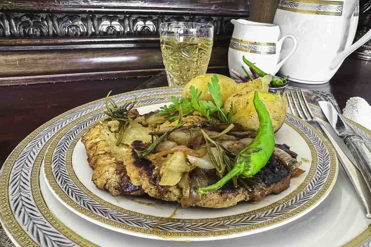 A plate of pork fillet meal garnished with onions.