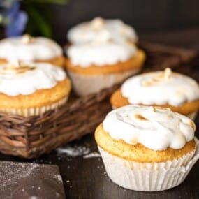 A basket with cupcakes topped with toasted frosting.