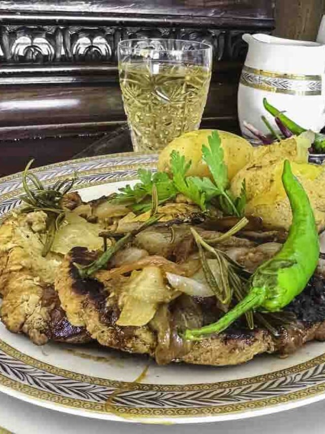 A plate of pork fillet meal garnished with onions.