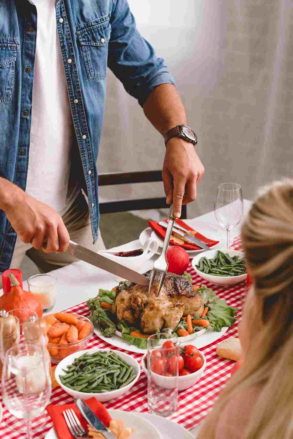 A person is carving a cooked chicken.