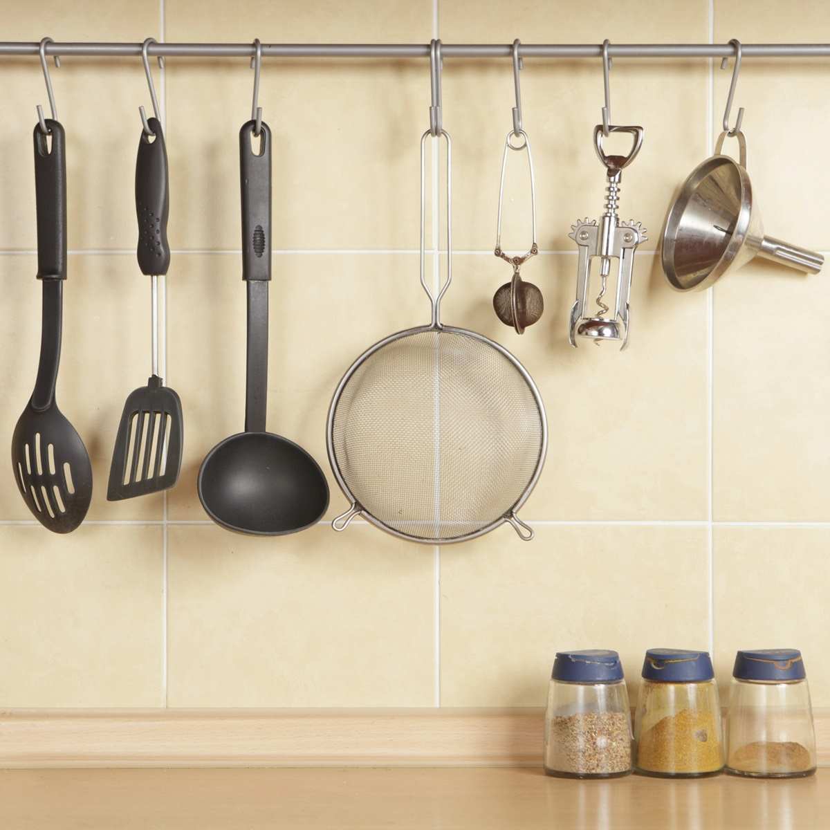 A kitchen wall with hanging utensils.