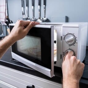 Adjusting a microwave oven's settings.