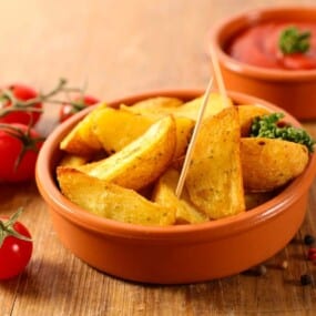 A bowl containing patatas bravas.