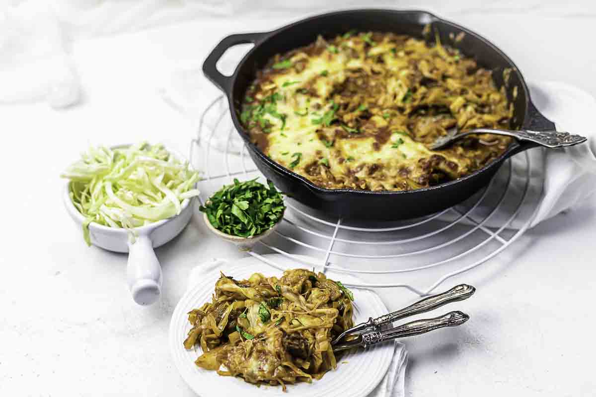 Beef casserole skillet with cabbage sides.