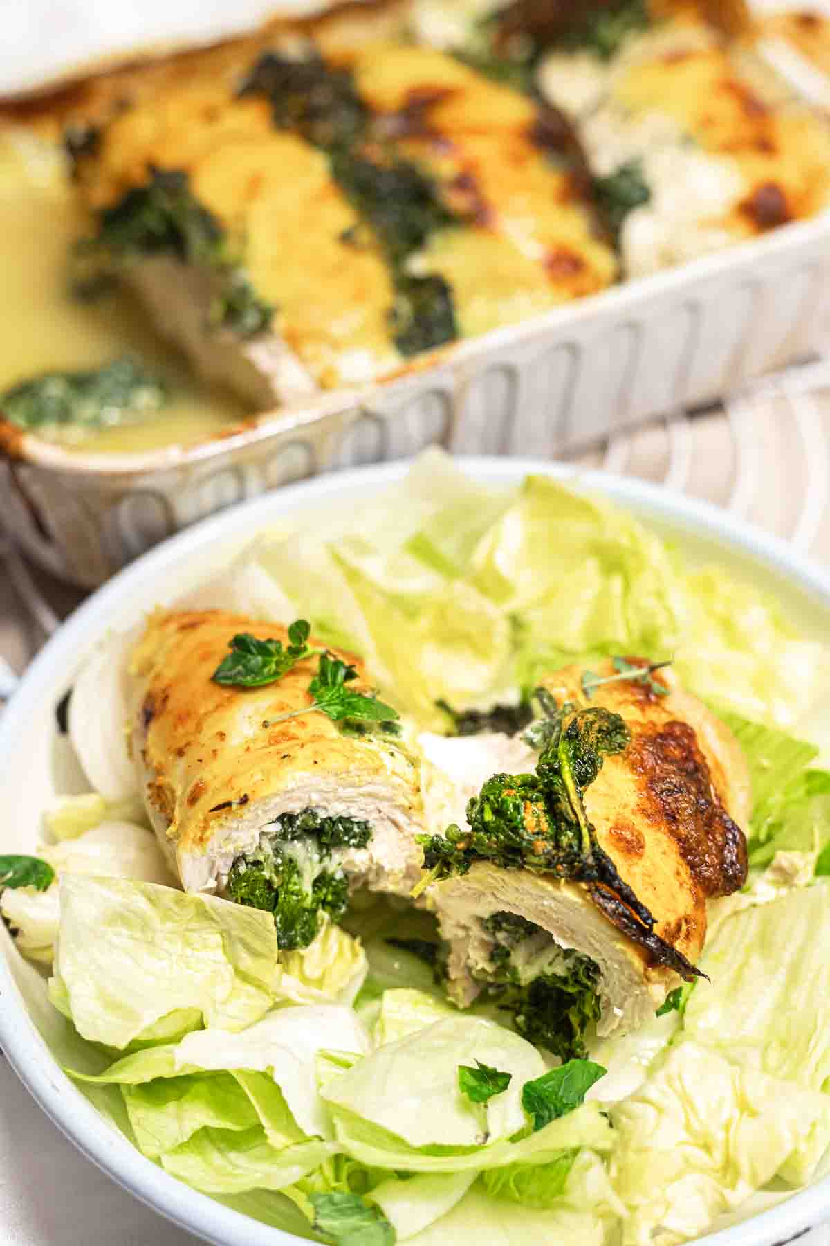 Baked chicken breast served with lettuce.