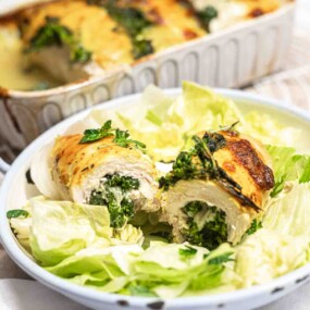 Cheesy stuffed chicken on lettuce bed.