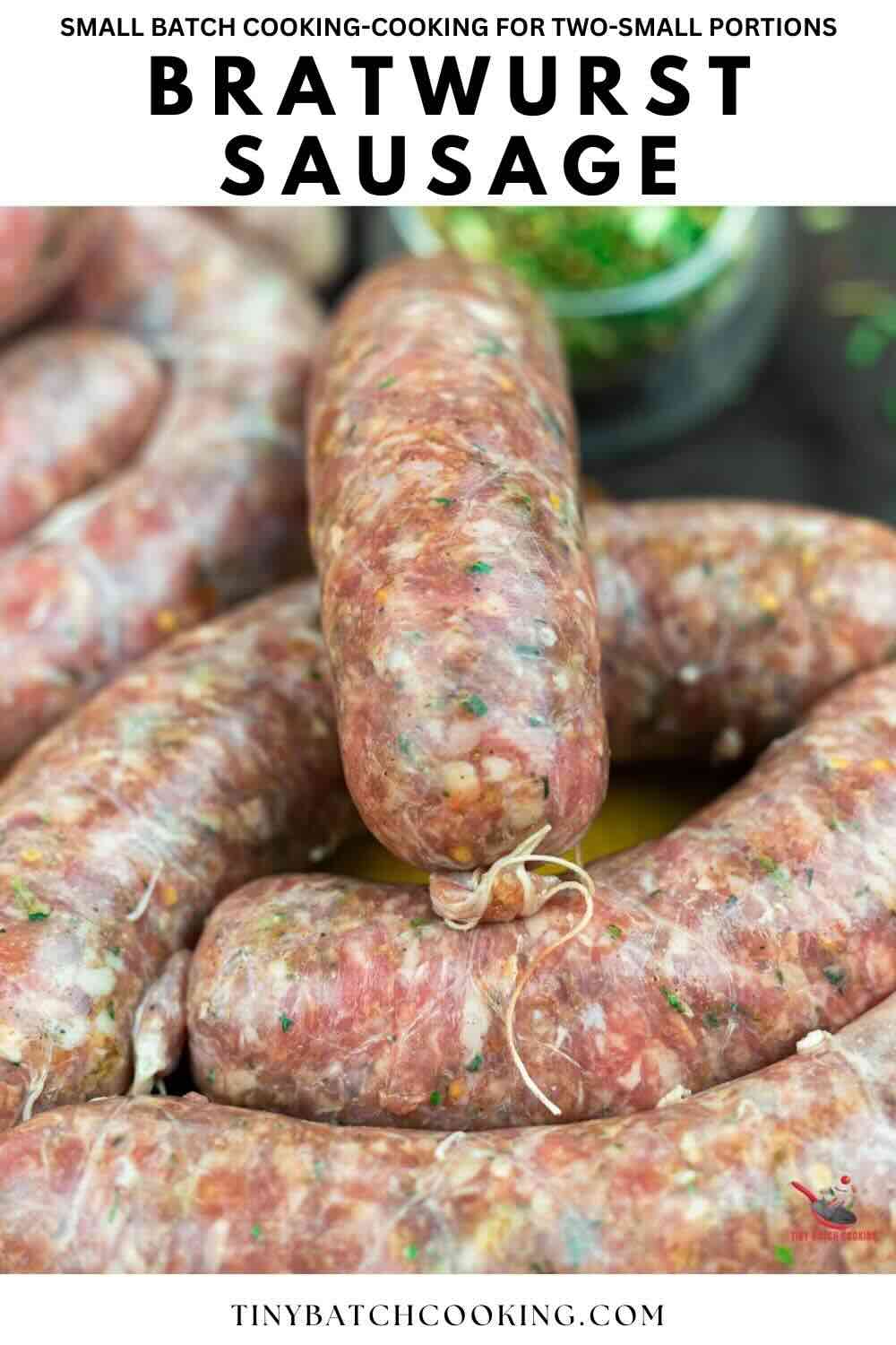 Close-up of raw bratwurst sausages piled together, showing their texture and tied ends, with herbs visible inside the casing.