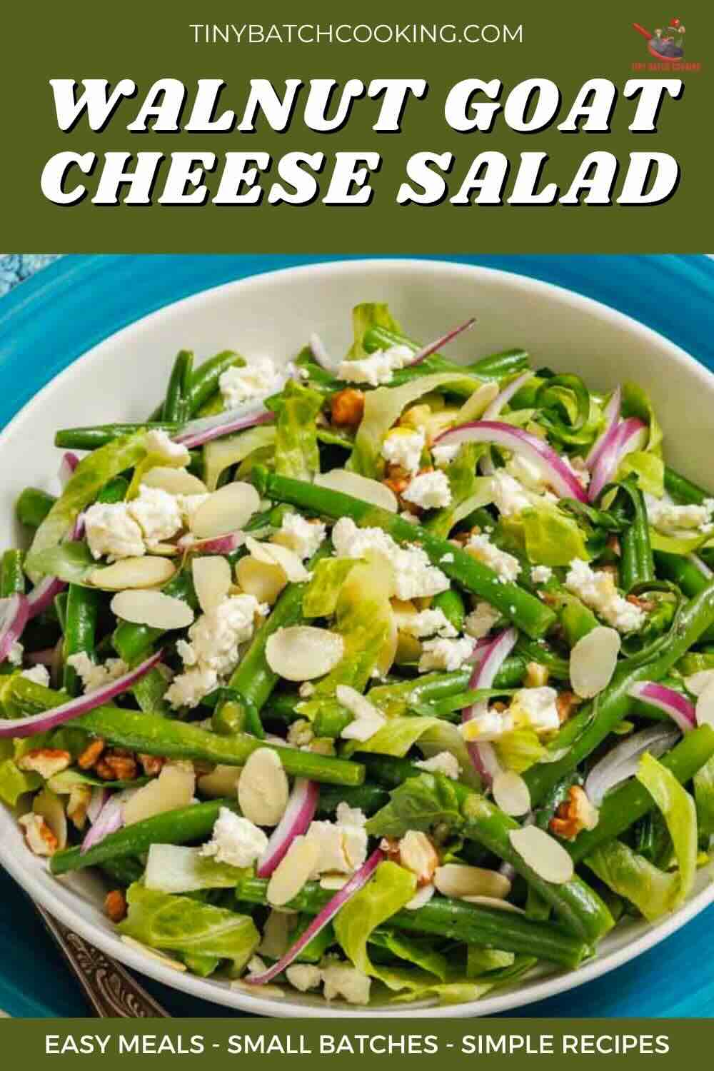 A bowl of walnut goat cheese salad with green beans, lettuce, red onion, sliced almonds, and crumbled goat cheese.