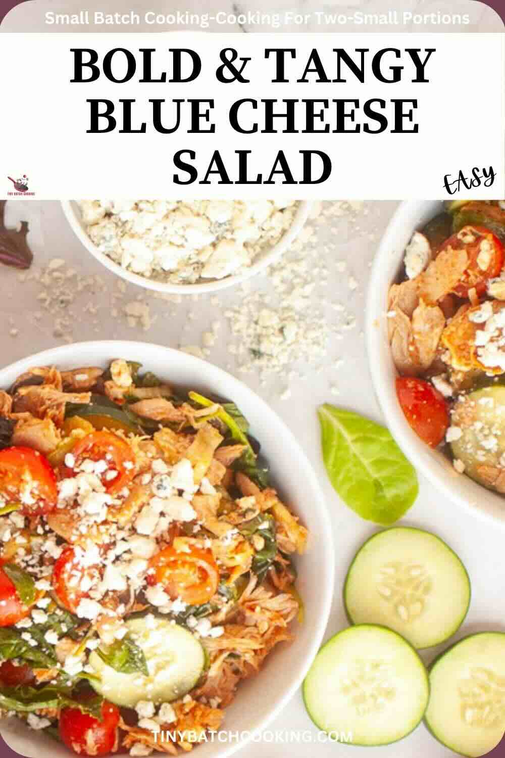 Overhead view of blue cheese salad with cherry tomatoes and shredded chicken in bowls, garnished with cucumber slices and a small dish of crumbled blue cheese.