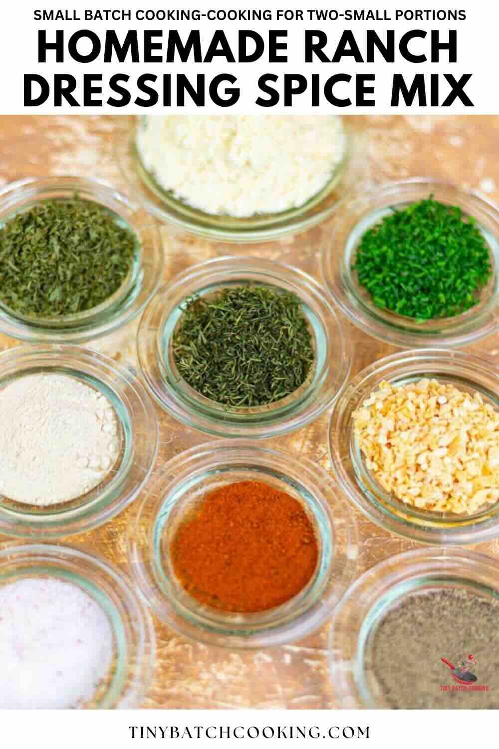 Nine small glass bowls filled with various dried herbs and spices are arranged on a tabletop, illustrating ingredients for a homemade ranch dressing spice mix.