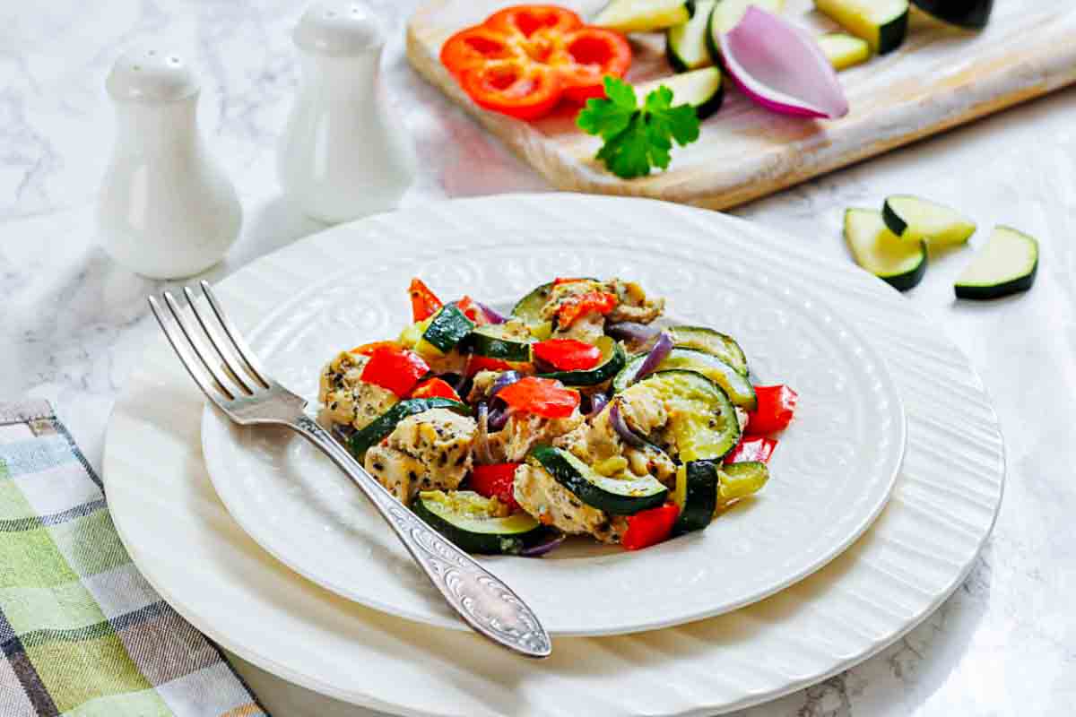Plate of chicken with mixed cooked vegetables.