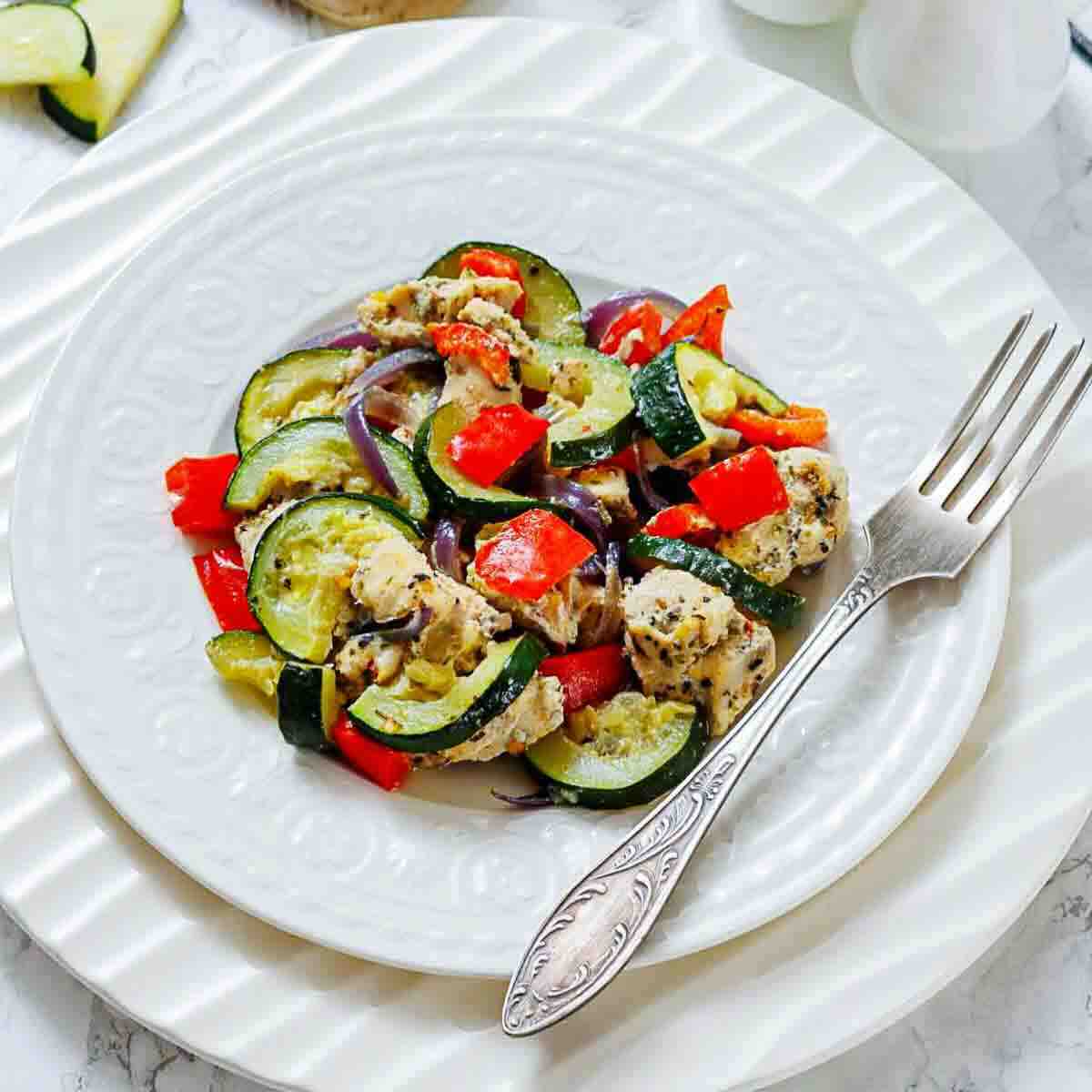 Chicken and sautéed vegetables arranged for serving.