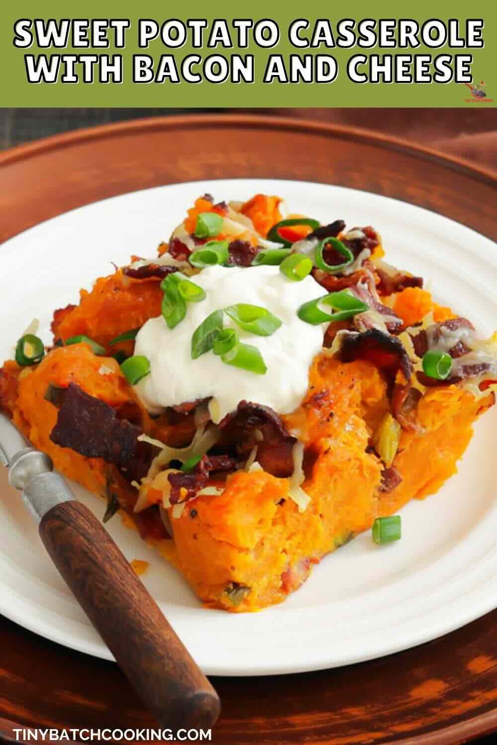 A serving of sweet potato casserole topped with bacon, cheese, sour cream, and green onions on a white plate with a fork.