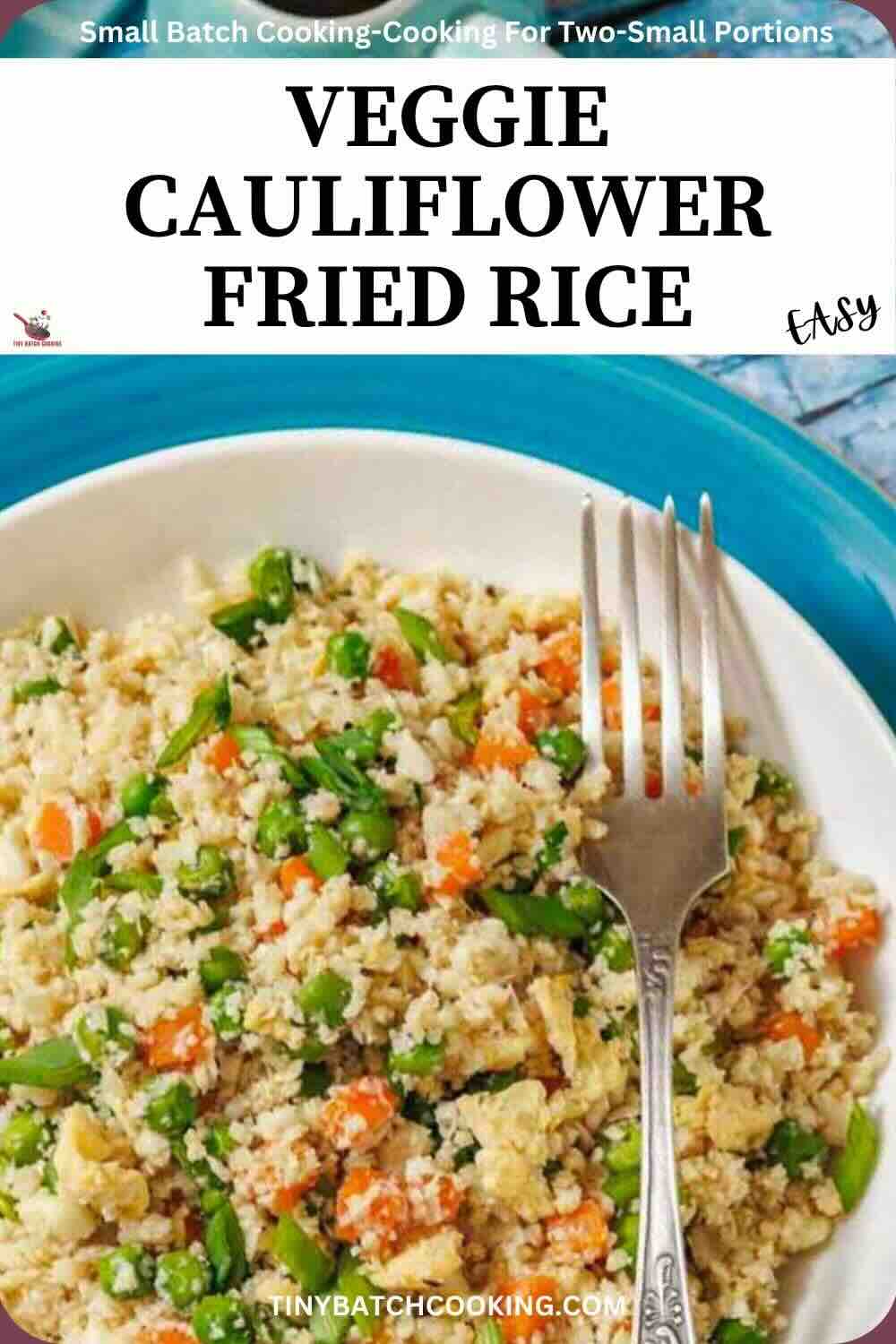 A plate of veggie cauliflower fried rice with peas, carrots, and green beans, served with a fork on a blue-rimmed plate.