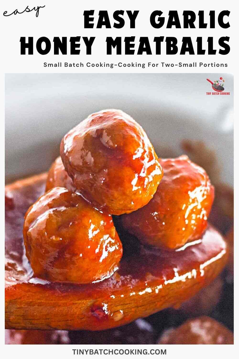 A wooden spoon holds three glazed meatballs covered in a shiny garlic honey sauce, with more meatballs and sauce in the blurred background.