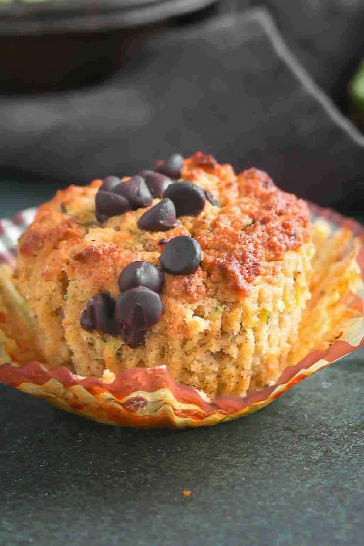A chocolate chip muffin in a paper liner.